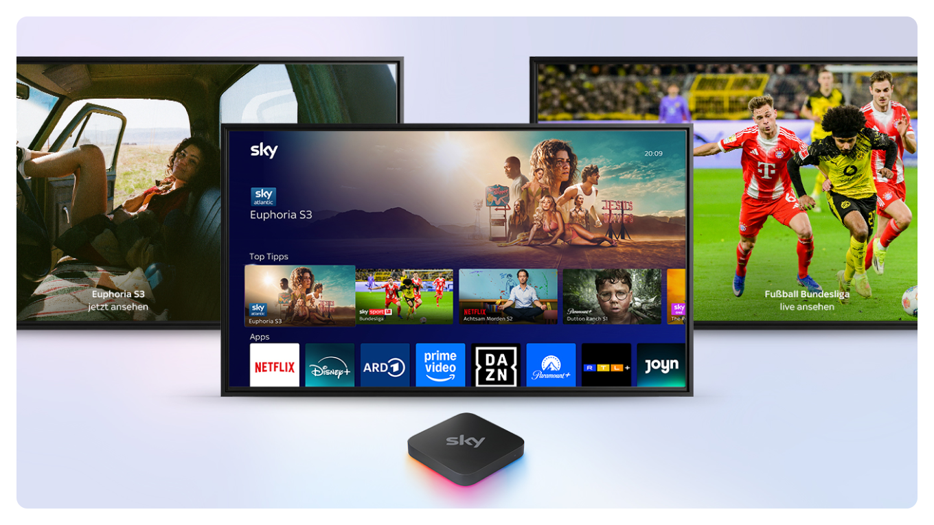 Sky Stream Box vor einem Fernseher, der das Sky Stream UI zeigt, versetzt dahinter zwei weitere Fernseher, die Inhalte von Sky zeigen.