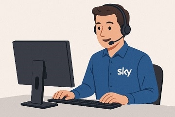 Sky Kundenservice-Mitarbeiter mit Headset arbeitet am Computer und unterstützt Kunden.
