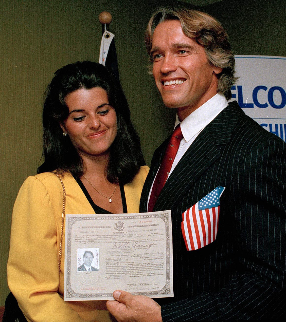 Arnold Schwarzenegger präsentiert am 16.9.1983 im Shrine Auditorium in Hollywood stolz seine US-Staatsbürgerschaftsurkunde, während Freundin und spätere Ehefrau, Maria Shriver, zusieht.