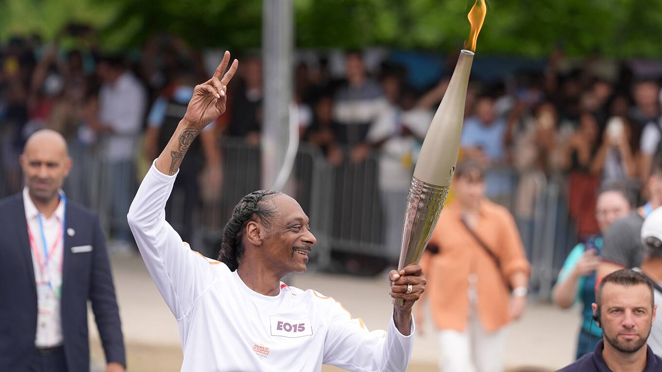 Foto von Rapper Snoop Dogg als Fackelträger des Olympischen Feuers bei den Olympischen Spielen 2024 in Paris.