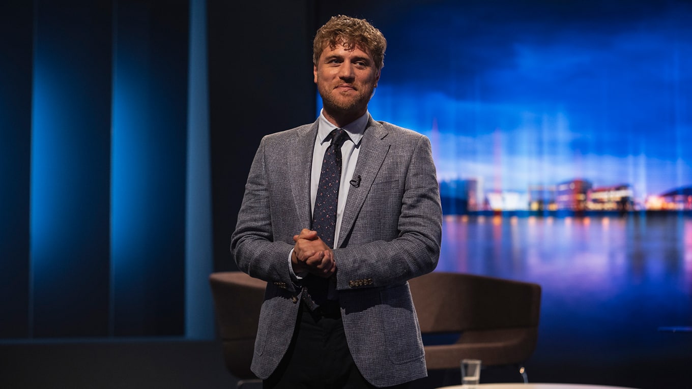 Johnny Flynn spielt Moderator Seamus in 